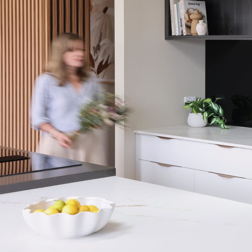 Woman arranging flowers in modern kitchen